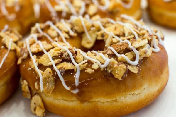 A vegan donut with caramel paste and honeycomb pieces.