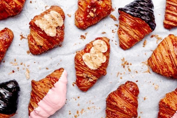 Croissants decorated with a range of toppings such as banana, strawberry sauce and dark chocolate.